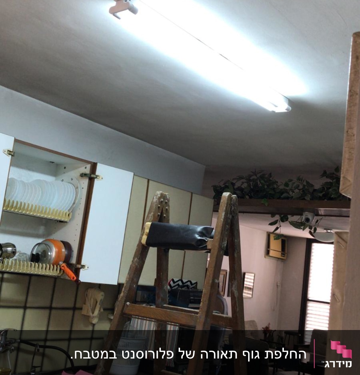 סולם עץ מתחת למנורת פלורסנט דולקת בתקרה